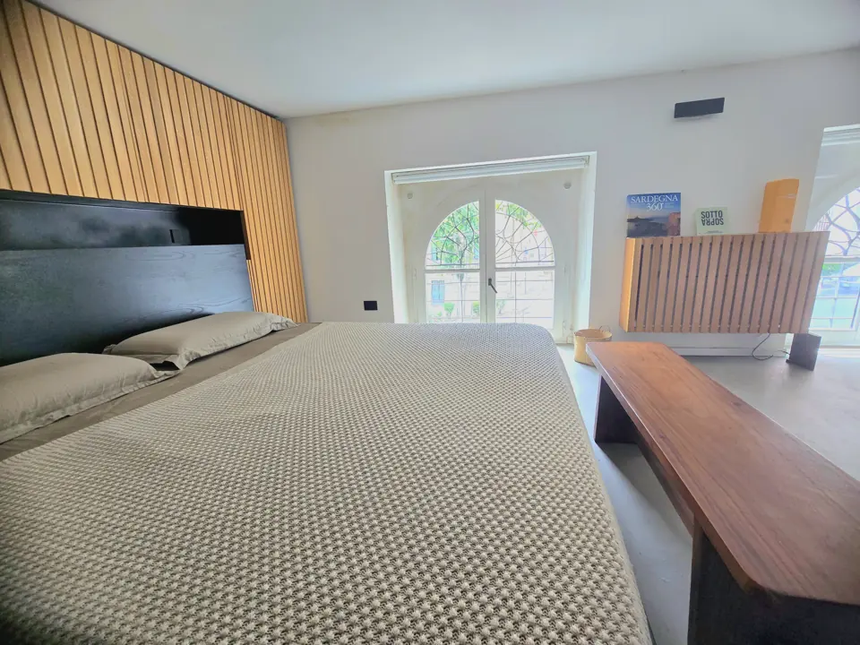Das große Bett und die Bogenfenster zur Allee